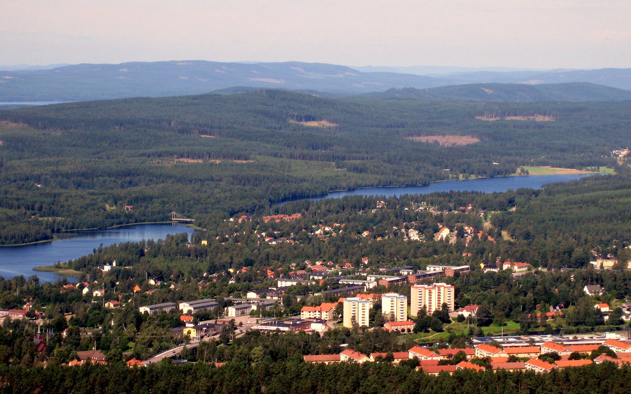 Hagfors från ovan en sommardag, med sjöarna, skogen och bostadshusen i centrum