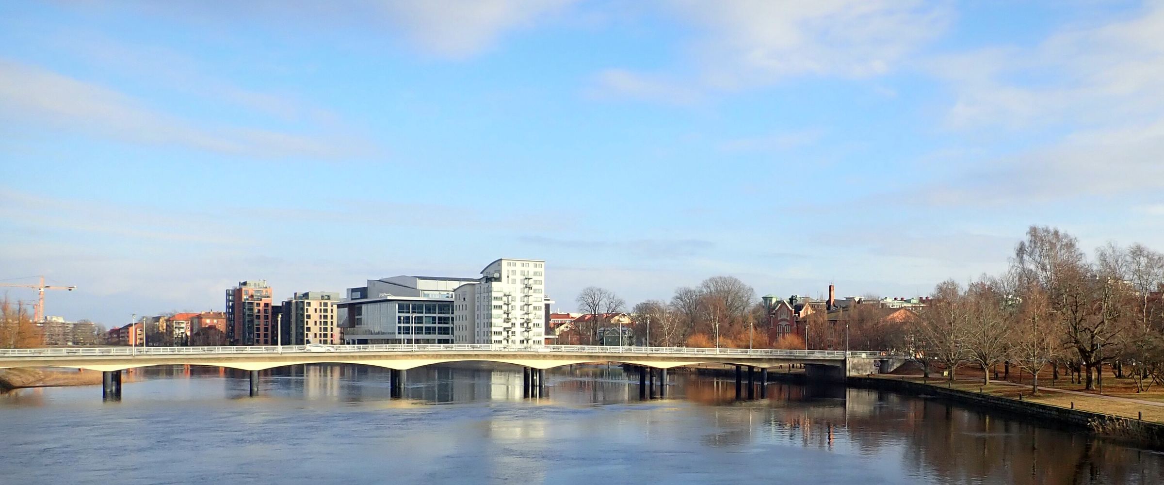 Klarälven genom Karlstad en solig dag, med en bro, stadens hus och ett kyrktorn